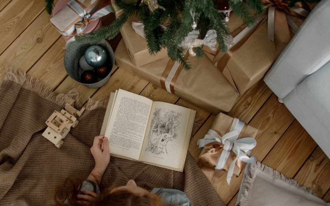 girl reading under a Christmas tree
